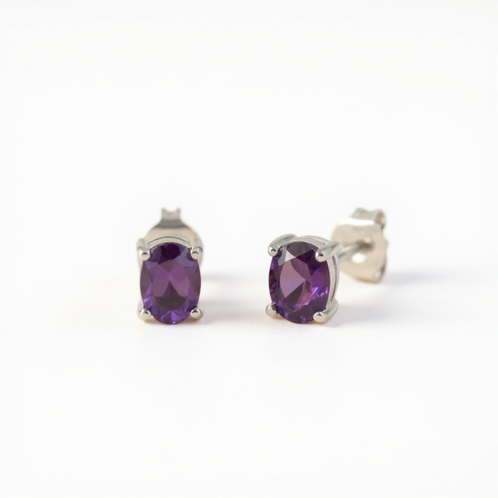 Sterling silver oval stud earrings with natural amethyst gemstones, displayed on a plain white background.