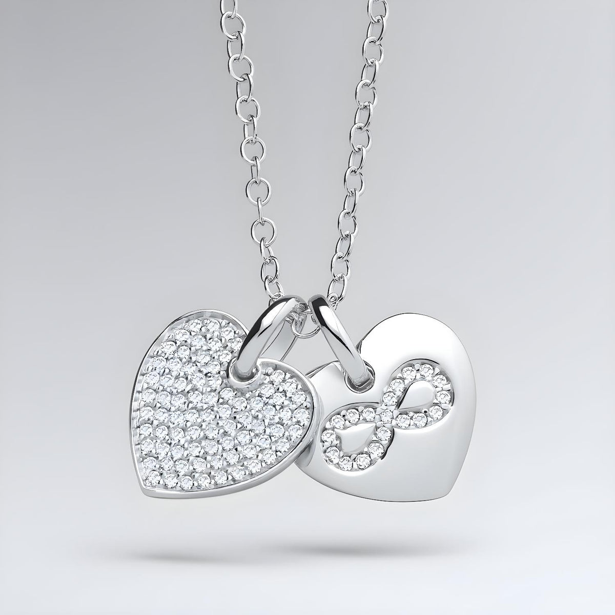 A sterling silver necklace with a CZ double heart and infinity charm, displayed against a plain background.