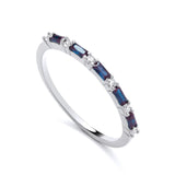 Sterling silver ring featuring an eternity design with alternating tanzanite baguettes and clear cubic zirconia stones.