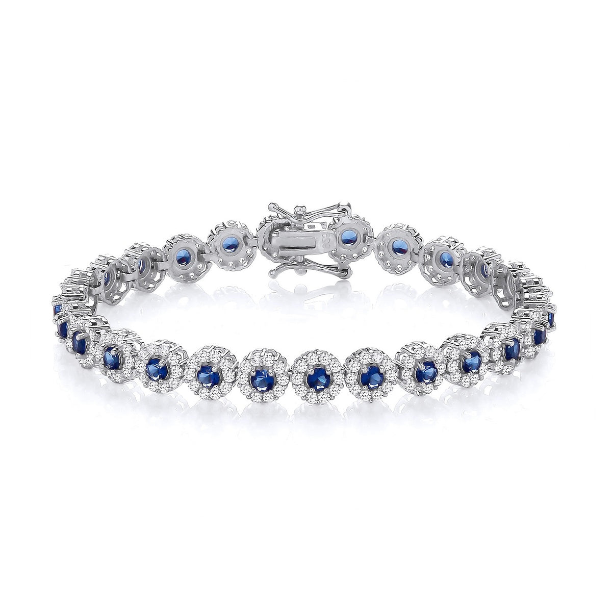 A sterling silver tennis bracelet with 6.5mm sapphires and CZ halos, shown with secure clasp on a white background.
