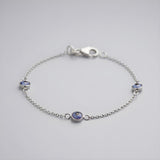 Sterling silver bracelet featuring three blue evil eye charms and a lobster clasp, displayed against a plain background.