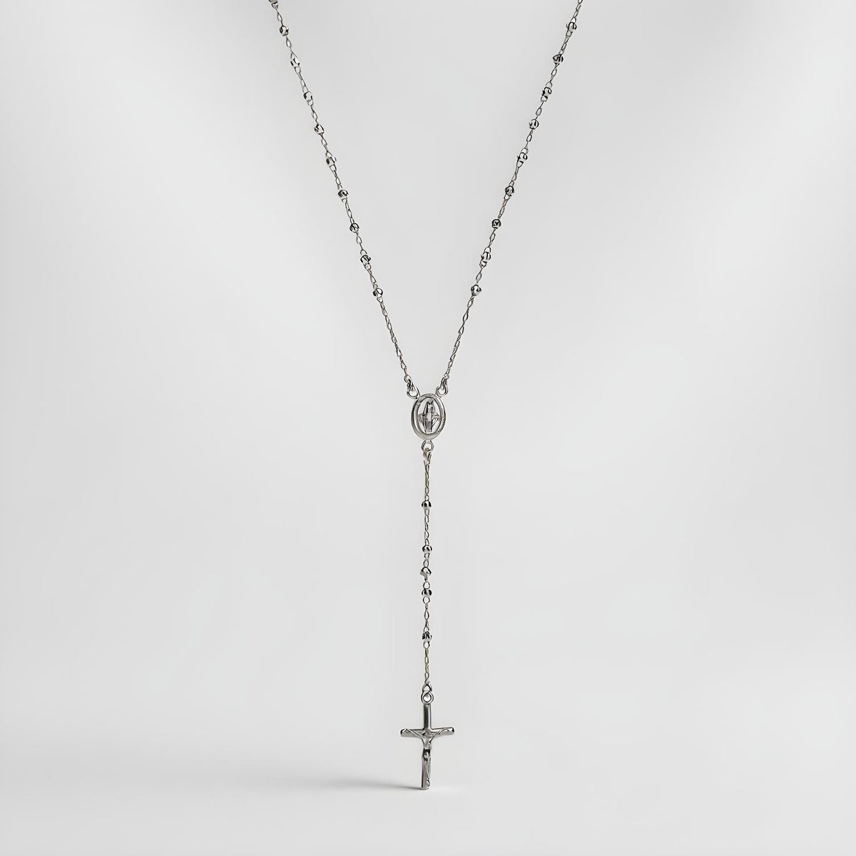 A Silversmiths Sterling Silver 24″ rosary bead necklace with a medallion and cross on a white background.