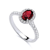 Sterling silver ring featuring a simulated ruby center, CZ halo, and sparkling stones set along the band.