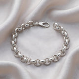 A 9.2mm plain sterling silver Belcher bracelet with a lobster clasp is displayed on textured fabric.