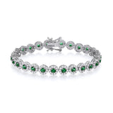 A sterling silver tennis bracelet with simulated emeralds and CZ halos, shown with a secure clasp on a white background.