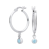 Silver hoop earrings with simulated aquamarine charms, representing the March birthstone, dangle from each earring.