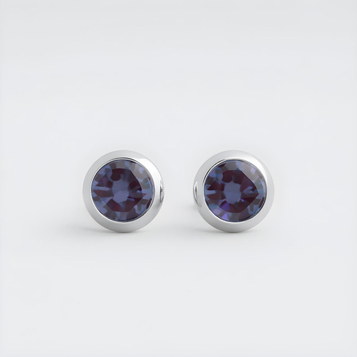 Sterling silver stud earrings by Silversmiths with 4mm simulated tanzanite in a modern bezel setting.