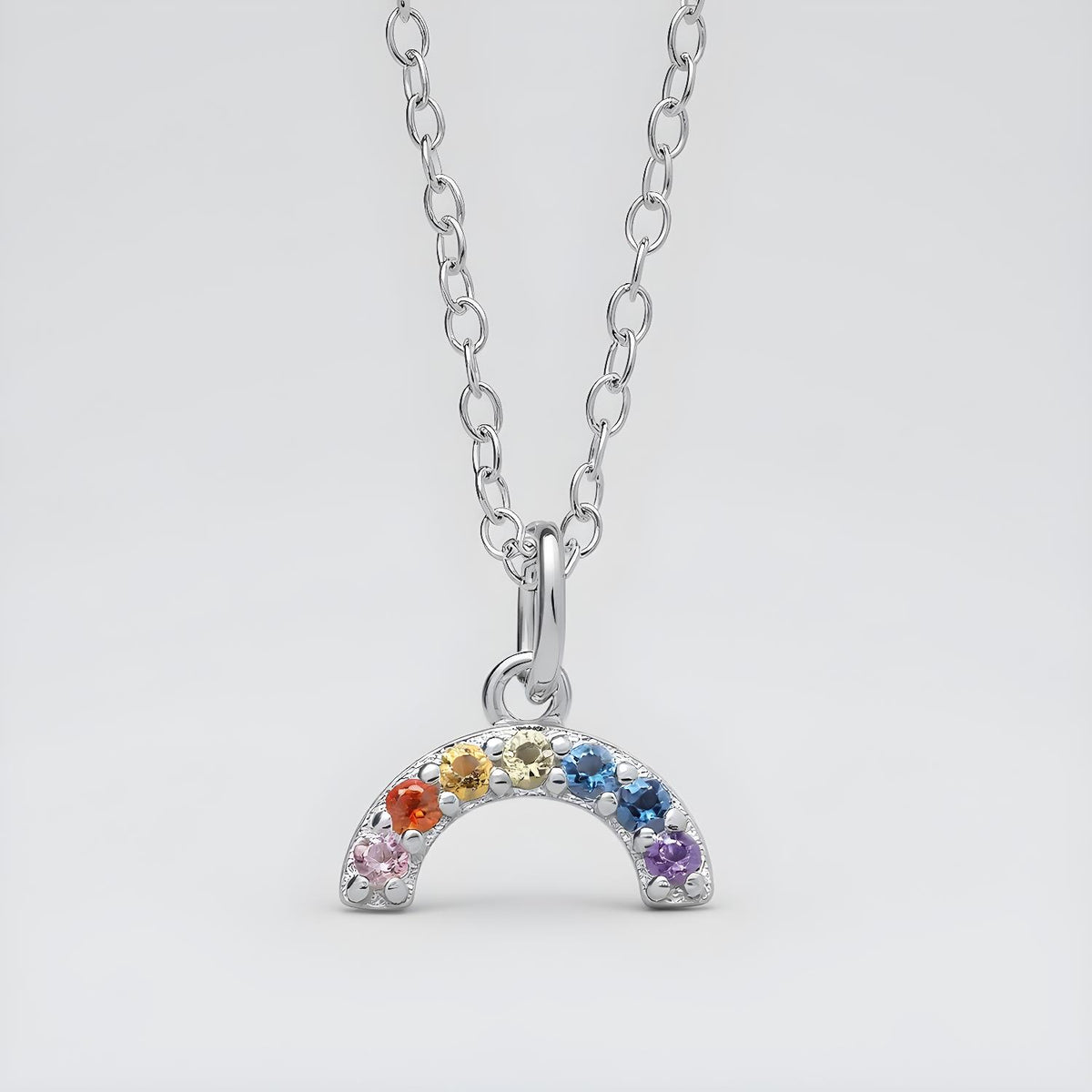 Sterling silver crescent moon necklace set with six colorful cubic zirconia gemstones.