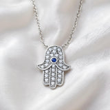 Sterling silver Hamsa necklace by Silversmiths with simulated sapphire, cubic zirconia, and a soft fabric chain.