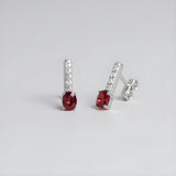 Sterling silver drop studs featuring simulated rubies and cubic zirconia accents.