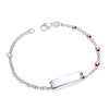 Sterling silver children’s ID bracelet with multiple ladybird designs, featuring red and black accents on a white plate.