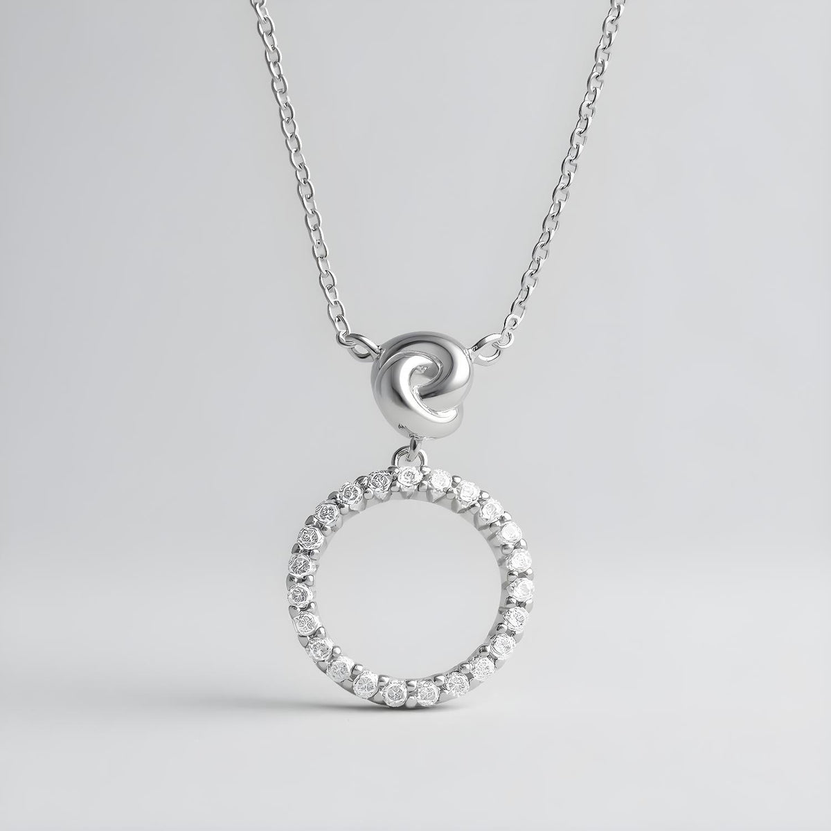 Sterling silver necklace featuring an infinity love knot circle design with cubic zirconia accents.
