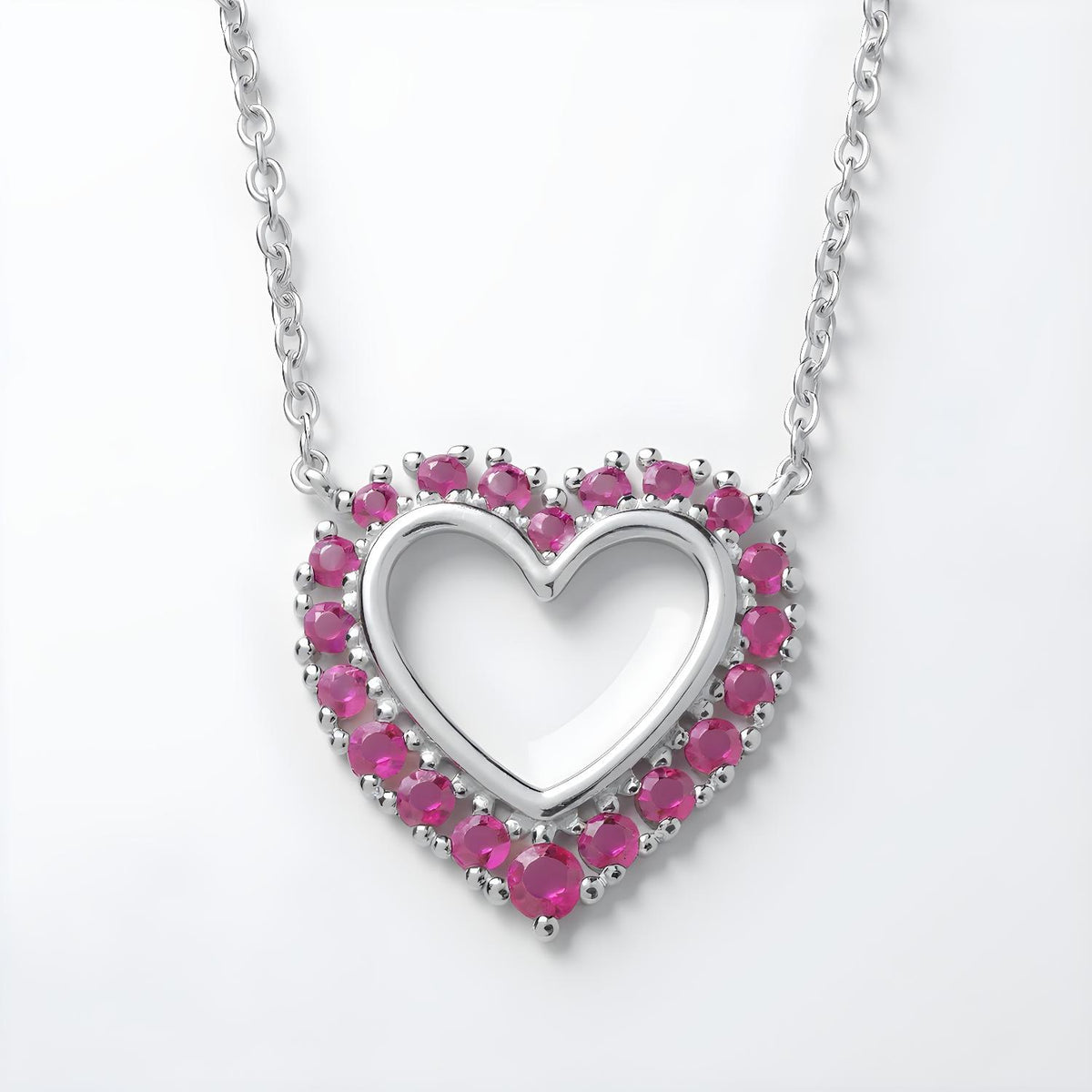 Sterling silver open heart necklace with simulated rubies and pink stones on a delicate chain.