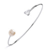 Silversmiths sterling silver torque bangle featuring a heart-cut cubic zirconia and a faux pearl accent.