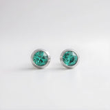 Silversmiths Sterling Silver stud earrings with 4mm simulated emeralds shown on a plain white background.