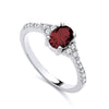 Sterling silver ring by Silversmiths featuring an oval simulated ruby and pavé accents along a smooth, slim band.