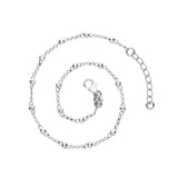 A Silversmiths sterling silver beaded rolo anklet with a 1″ extender is coiled on a plain white background.