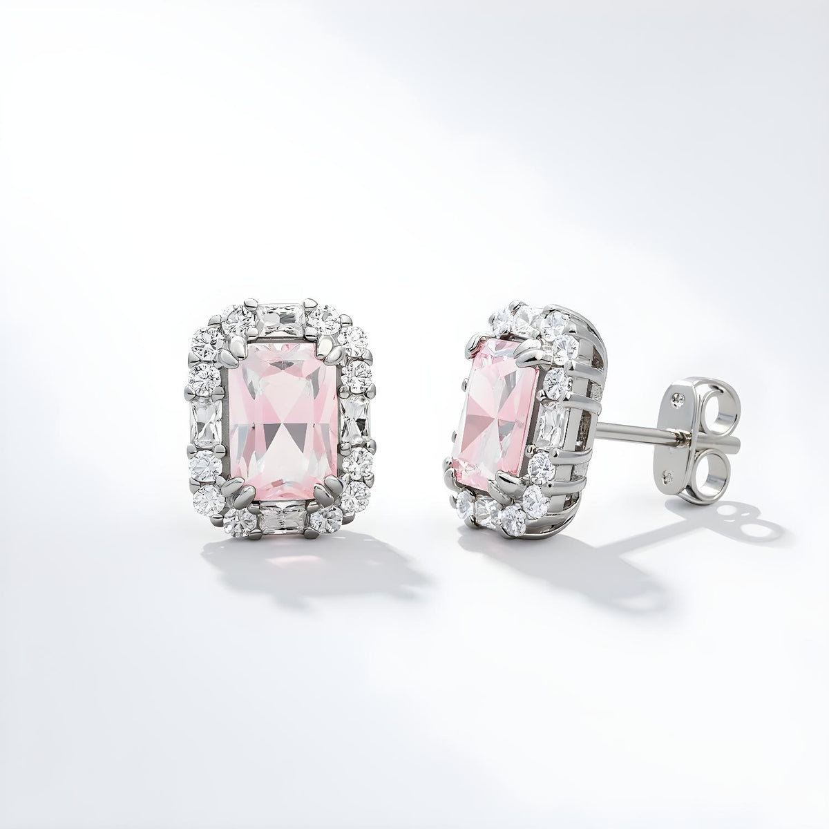 Sterling silver stud earrings with simulated pink sapphires encircled by a sparkling halo design.
