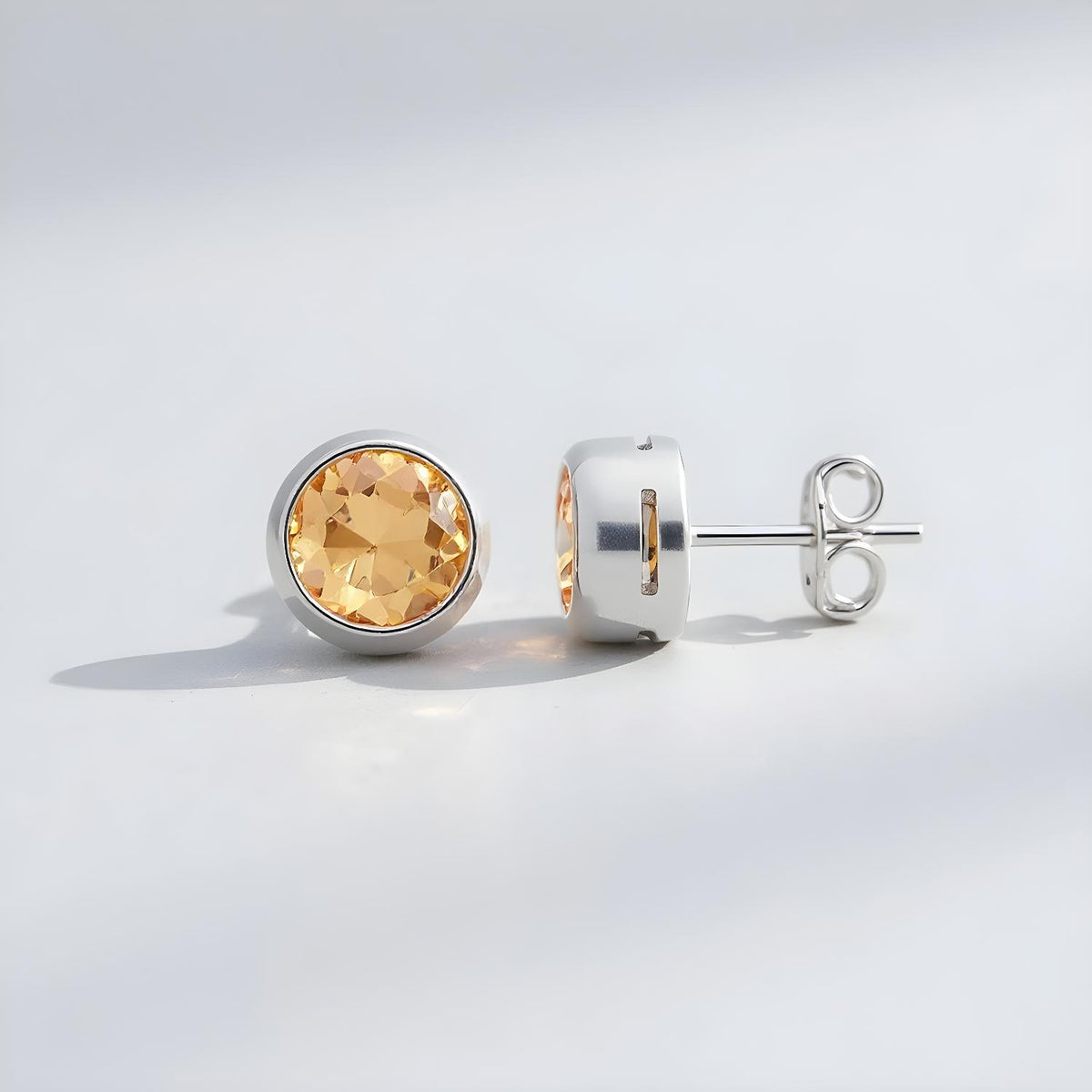 Sterling silver stud earrings feature round natural citrine stones, displayed against a light background.