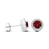 Sterling silver stud earrings with round simulated ruby centers and clear pavé stone halos.