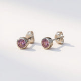 Silversmiths sterling silver stud earrings feature round simulated amethyst stones against a white background.