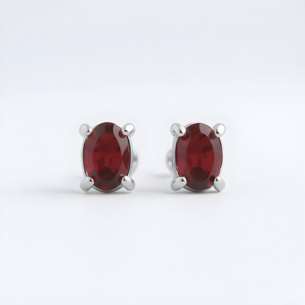 Silversmiths sterling silver stud earrings with natural oval garnets.