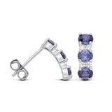 These sterling silver earrings have three simulated tanzanite stones in a vertical drop with sparkling accents.