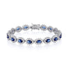 A sterling silver bracelet featuring oval simulated sapphires in a halo design is shown on a white background.