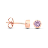 Rose gold plated silversmith studs with faceted Alexandrite in bezels, shown from side and front on white background.