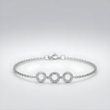 A sterling silver bracelet with three cubic zirconia circle stations is pictured on a plain background.