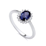 Sterling silver ring by Silversmiths featuring a simulated sapphire center and cubic zirconia accents on a thin band.