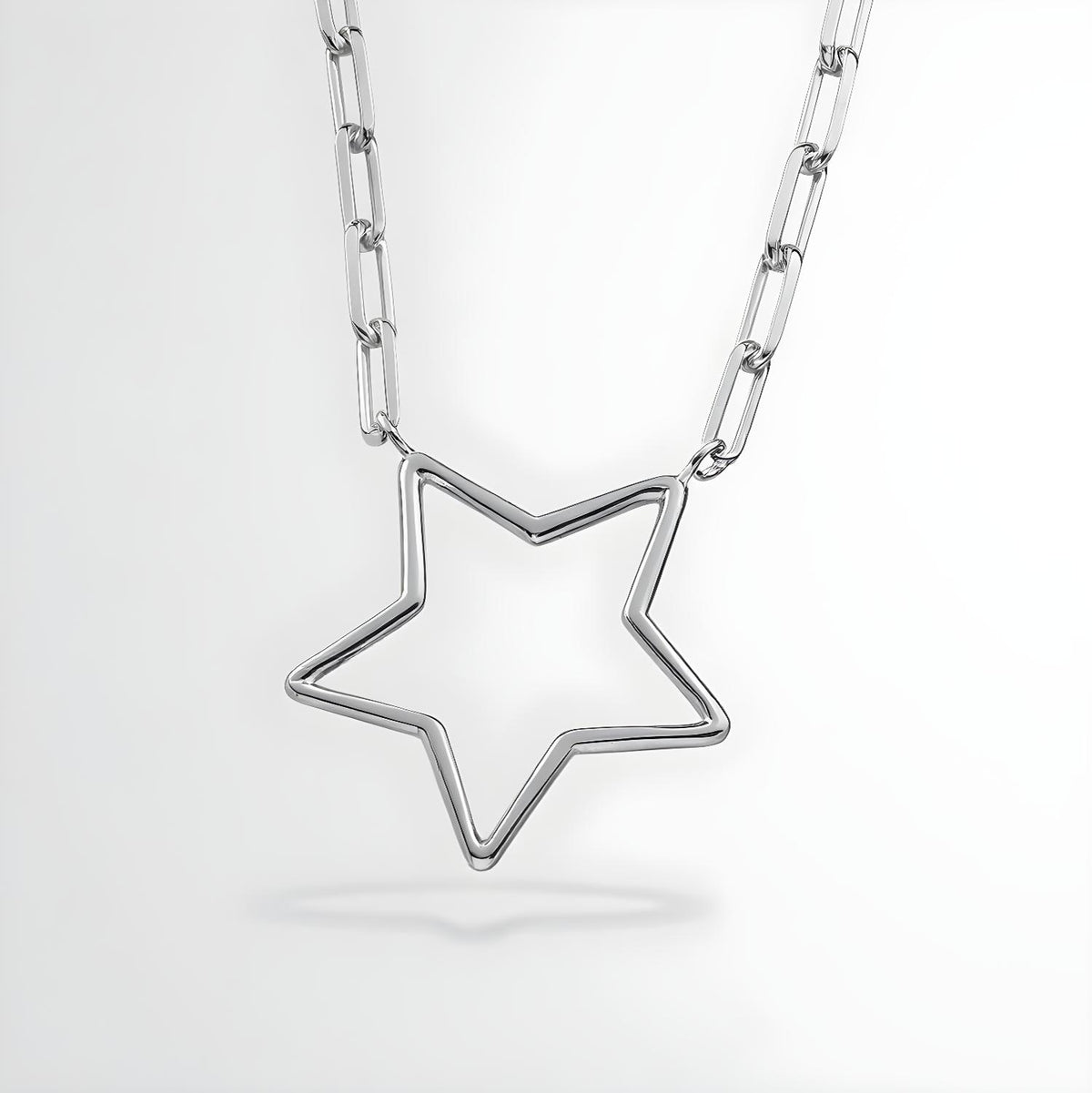 A sterling silver paperclip chain necklace with an open star pendant displayed on a plain white background.