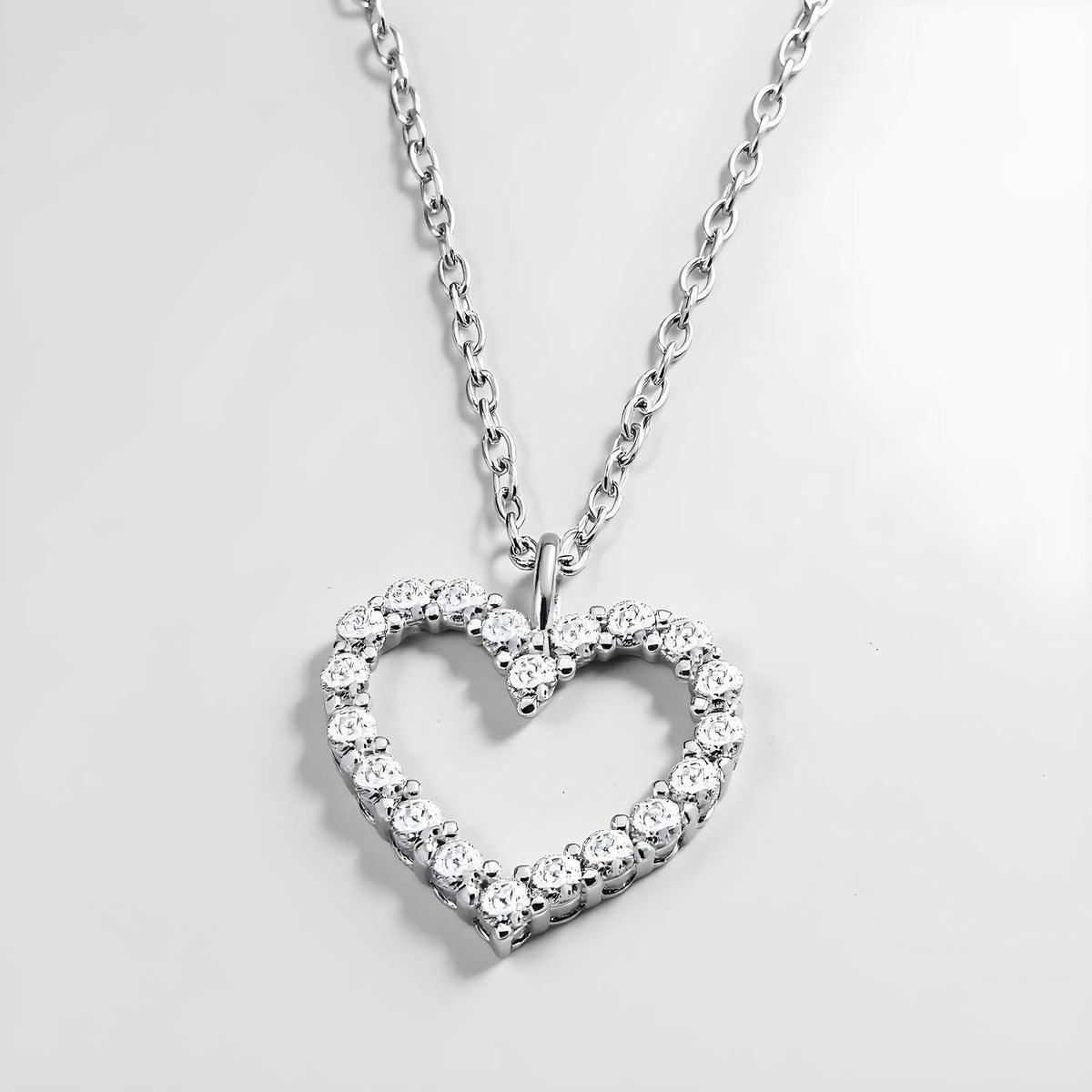 Sterling silver heart necklace by Silversmiths features cubic zirconia stones on a fine, delicate chain.