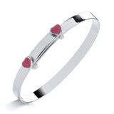 Sterling silver expanding baby bangle with pink enamel heart, heart charms, and a simple bar on a white background.