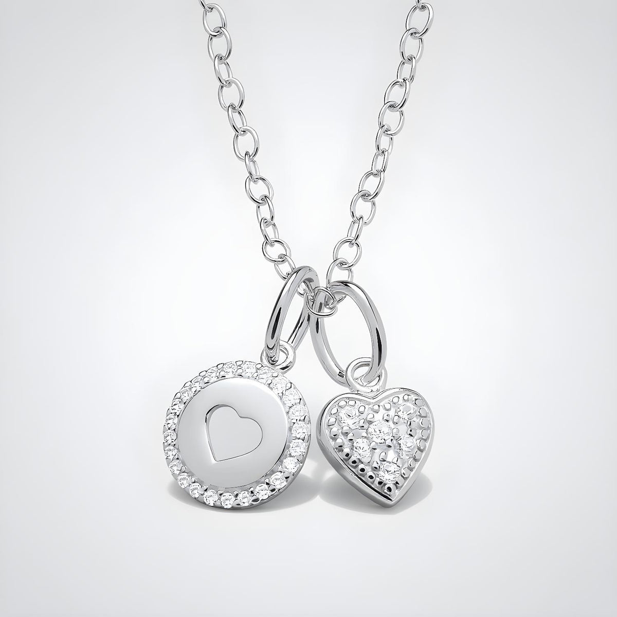 Sterling silver necklace featuring a cubic zirconia heart charm with halo and gem accents.