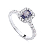 Sterling silver ring featuring a simulated tanzanite center and a cubic zirconia halo on a polished band.