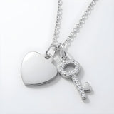 Sterling silver necklace with cubic zirconia heart and key pendants that have a sparkling finish.