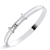 Sterling silver baby bangle from Silversmiths features heart cutouts and two bars on a reflective white background.