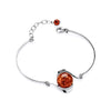 A Sterling Silver bracelet features a round Cognac Baltic amber cabochon and an adjustable chain against a white background.