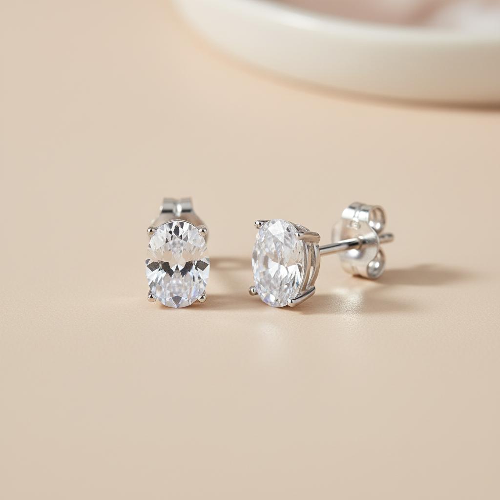 Silversmiths sterling silver oval cubic zirconia stud earrings shown on a light beige surface.