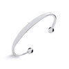 A minimalist sterling silver baby torque bangle with an ID plate is displayed on a plain white background.