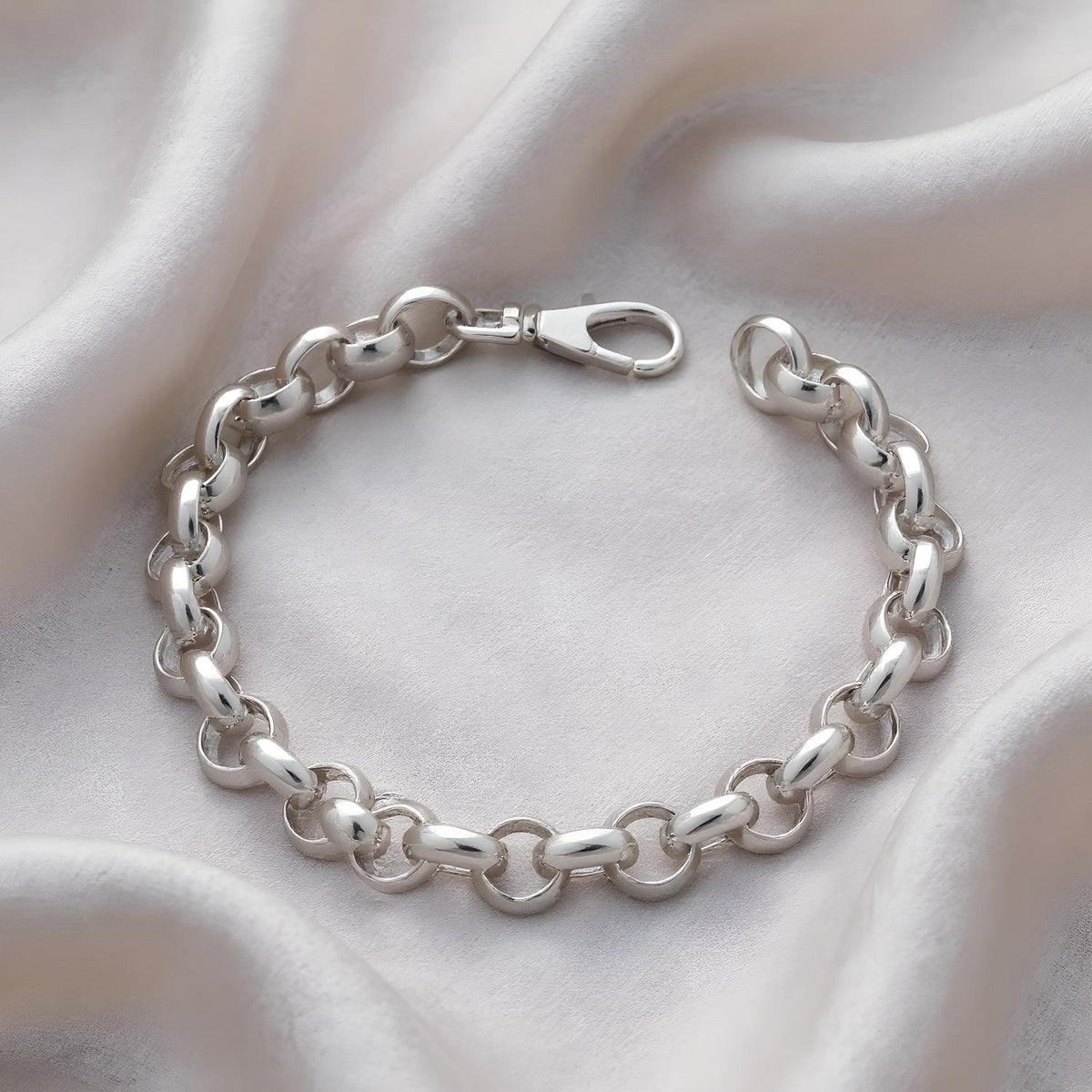 A 9.2mm plain sterling silver Belcher bracelet with a lobster clasp is displayed on textured fabric.