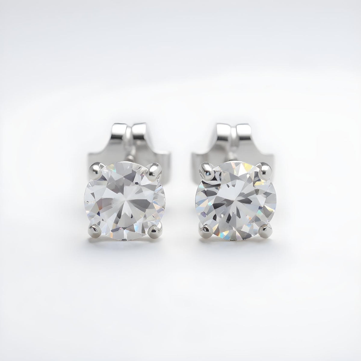 Silversmiths Sterling Silver stud earrings with 4mm round cubic zirconia and butterfly backs on a white background.