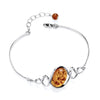 Sterling silver bracelet with a cognac Baltic amber stone, swirl hook design, and adjustable chain.