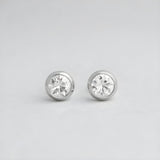 4mm sterling silver bezel-set cubic zirconia stud earrings with a minimalist design on a light gray background.