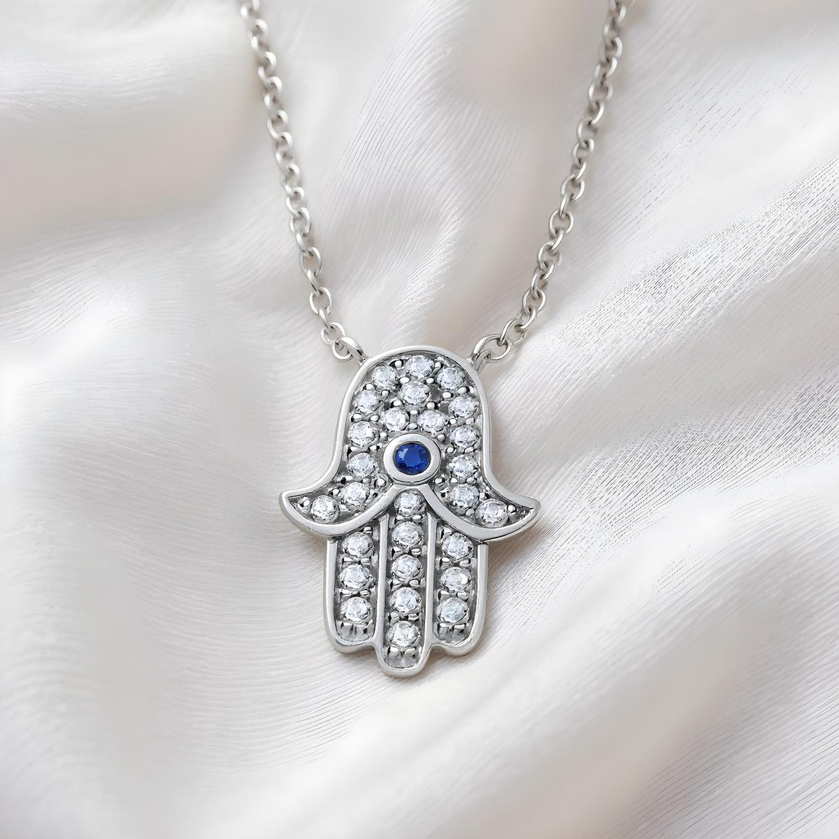 Sterling silver Hamsa necklace by Silversmiths with simulated sapphire, cubic zirconia, and a soft fabric chain.