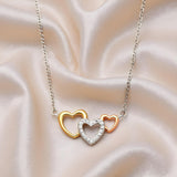 Triple Heart Necklace with rose, yellow, and silver hearts, each accented with cubic zirconia on ivory fabric.