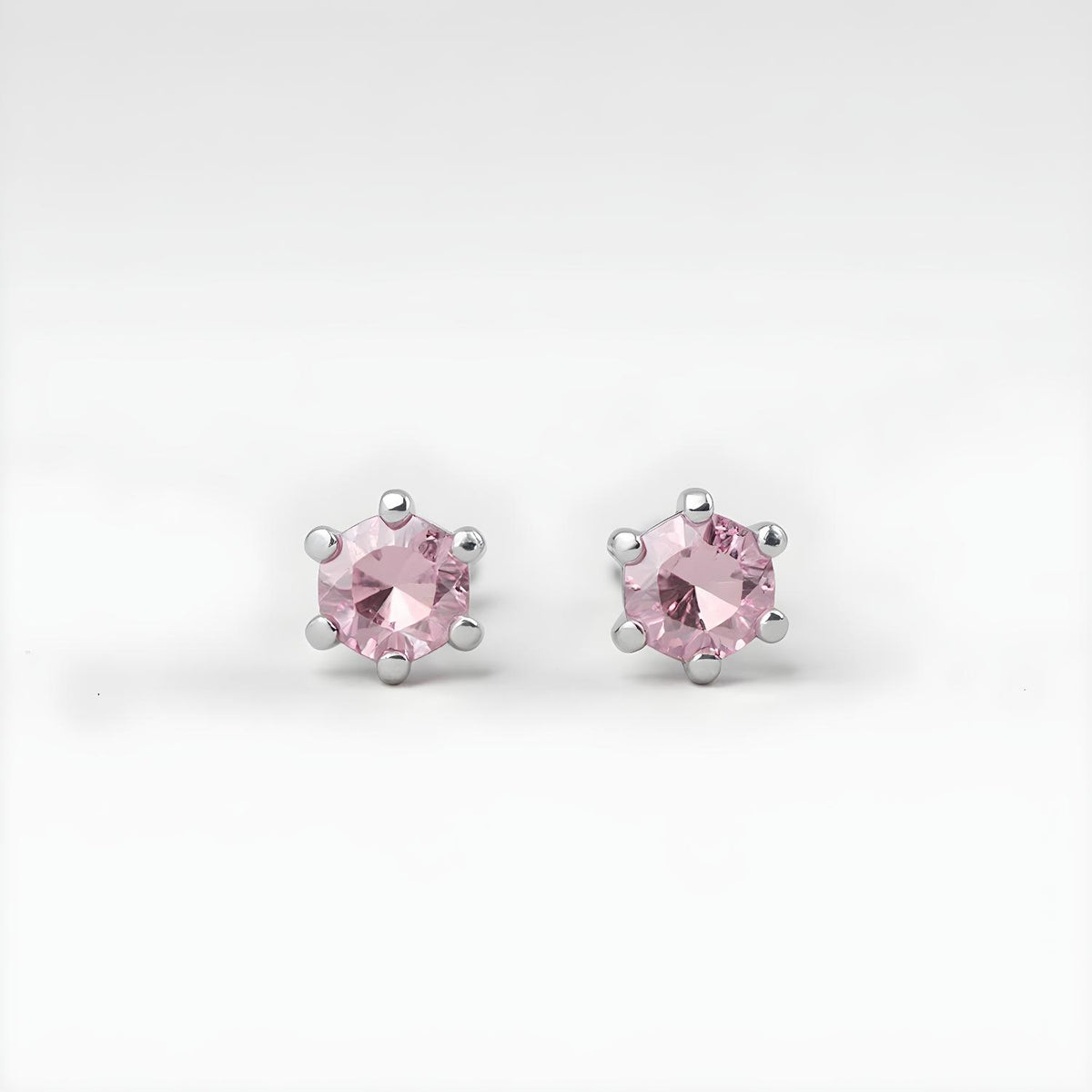 Silversmiths sterling silver stud earrings feature pink topaz stones in six-prong settings.