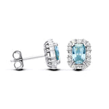 Silversmiths silver stud earrings feature blue simulated aquamarine stones surrounded by a sparkling halo accent.