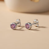 Sterling silver stud earrings feature round simulated amethyst stones set in simple bezel settings.